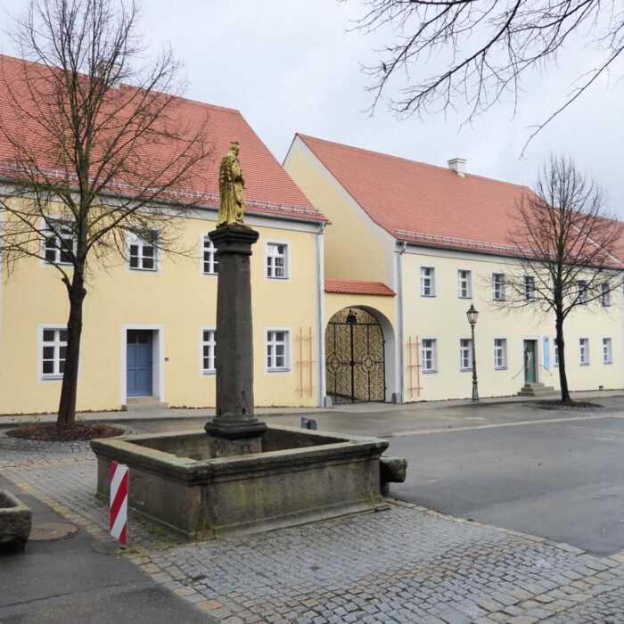 Steinfontaene vor gelbem Gebäude - Thammeranwesen Winklarn